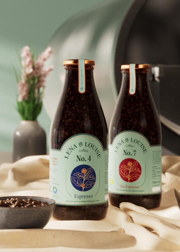 Kaffeeflaschen von Lena & Louise Coffees vor einem Kaffeeröster in der Rösterei in Ravensburg – Headerbild der Über-uns-Seite.